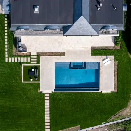 Aerial view of a backyard with a new inground pool and outdoor furnishings.