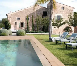 Elegant outdoor space featuring a swimming pool, lounge chairs, and landscaped garden in Long Island. Beautiful backyard with inground pool, outdoor lounge chairs, and lush landscaping in Long Island.