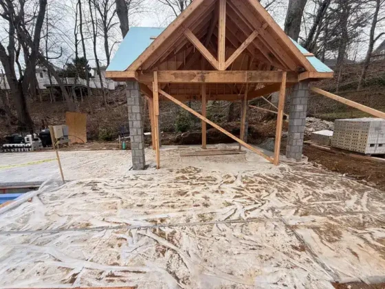 Construction site of an inground pool with wooden structure and concrete foundation.