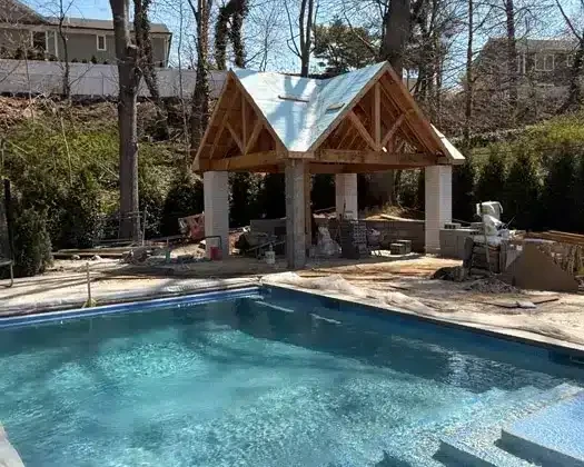 Inground pool with new outdoor pavilion under construction in Long Island.