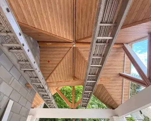 Construction ceiling with ladders and wooden panels in progress.