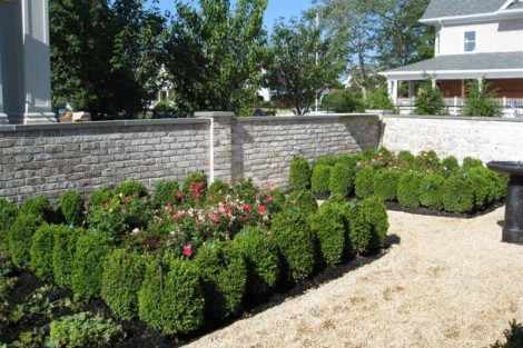 A neatly landscaped garden featuring trimmed shrubs and flowering plants, enhancing curb appeal and outdoor aesthetics. Well-maintained garden with trimmed shrubs and flowering plants in a residential yard.