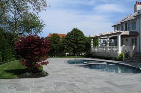 Elegant backyard featuring a custom inground pool, patio, and outdoor furnishings in Long Island, perfect for outdoor living. Beautiful backyard with inground pool, patio, and outdoor furnishings in Long Island.