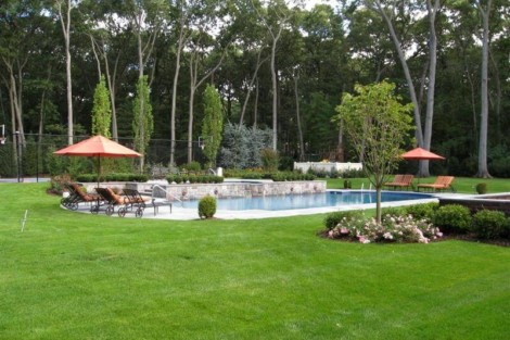 Elegant backyard featuring a custom inground pool, outdoor seating, and vibrant landscaping for outdoor living. Beautiful backyard with inground pool, outdoor furniture, and lush landscaping.