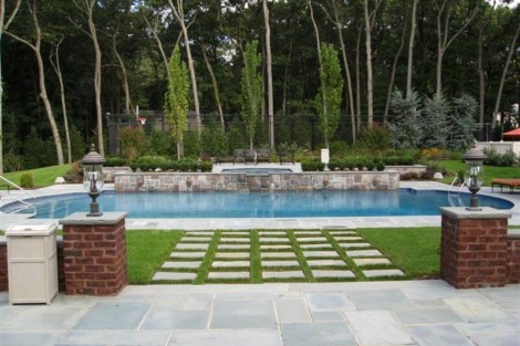Elegant backyard featuring a custom inground pool, outdoor seating, and landscaped surroundings in Long Island. Beautiful backyard with inground pool, outdoor furniture, and lush landscaping in Long Island.