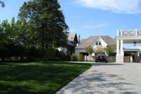 Beautiful Long Island residence featuring a spacious driveway, lush landscaping, and outdoor furnishings. Long Island home with driveway, outdoor landscaping, and outdoor furnishings.