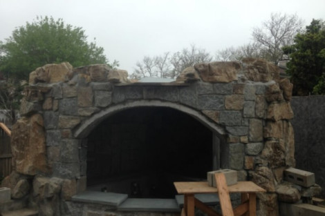 Stone structure with archway, part of a custom outdoor landscaping project on Long Island. Stone outdoor structure with archway for landscaping projects.