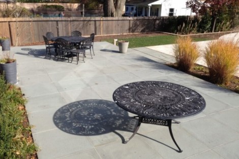 Stylish outdoor patio featuring black metal dining table and chairs, perfect for outdoor gatherings and relaxation. Modern outdoor patio with black metal furniture and decorative table.