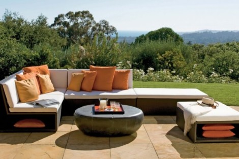 Elegant outdoor sectional sofa with cushions and coffee table overlooking a scenic landscape. Modern outdoor sectional sofa with cushions and coffee table on patio.