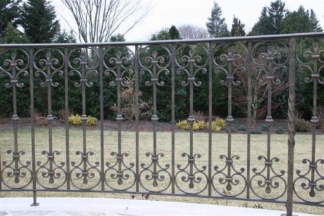 Stylish iron fencing installed in a backyard, enhancing privacy and aesthetic appeal. Decorative iron fence with intricate scrollwork for outdoor security.