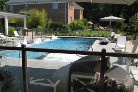 Beautiful backyard with inground pool, outdoor furniture, and lush landscaping in Long Island. Luxury inground pool with outdoor furnishings in Long Island backyard.