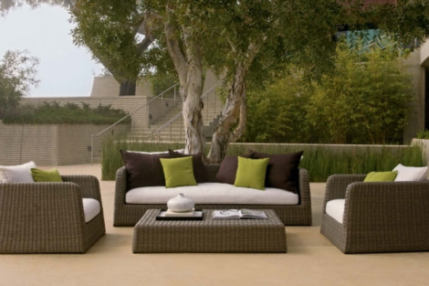 Stylish outdoor furniture set with cushions, perfect for relaxing by the pool or outdoor entertaining. Elegant outdoor furniture set with cushions near a tree on a patio.