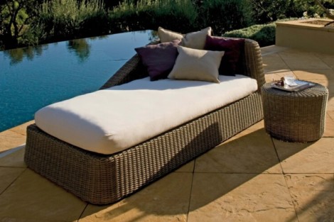 Elegant wicker outdoor lounge with cushions, perfect for relaxing by the pool on Long Island. Wicker outdoor lounge with cushions by the poolside.