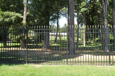 Durable black metal fence installed in a lush park environment on Long Island by All Island Group. Black metal fence with decorative spikes in a green park setting.
