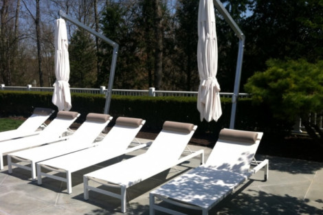 Comfortable outdoor lounge chairs with umbrellas, perfect for relaxing in outdoor living spaces. Outdoor lounge chairs with umbrellas on patio for outdoor living.