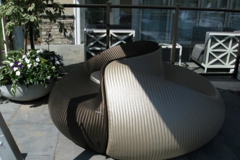 Contemporary outdoor lounge chair with a rounded, comfortable design on a patio setting. Modern outdoor lounge chair with unique rounded design on patio.