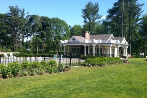 Luxury pool house with fencing and outdoor furnishings in Long Island, perfect for outdoor living and entertaining. Beautiful pool house with fencing and lush lawn in Long Island.