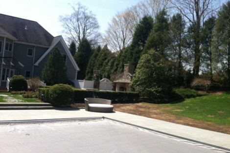 Beautiful backyard with inground pool, outdoor furnishings, and lush landscaping in Long Island. Long Island inground pool with outdoor furniture and landscaping.