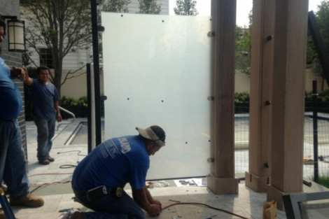 All Island Group installing pool fencing with glass panels and wooden posts in Long Island. Pool fencing installation by All Island Group in Long Island.