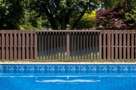 Beautiful inground pool with privacy fencing and surrounding trees for a serene outdoor space. Long Island inground pool with privacy fence and lush greenery.