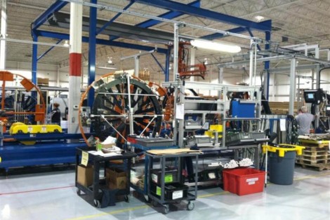 Factory floor with machinery, workstations, and tools for manufacturing processes. Industrial manufacturing machinery and workstations in a factory setting.