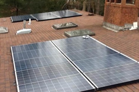 Solar panels installed on a residential roof to harness solar energy and promote green energy solutions. Solar panels installed on a residential roof for renewable energy.
