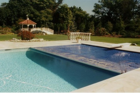 Elegant inground pool with automatic cover, outdoor furnishings, and scenic backyard setting in Long Island. Luxury inground pool with automatic cover and outdoor furnishings.
