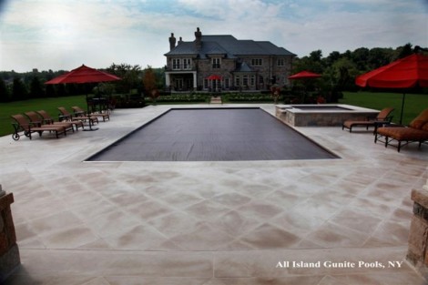 Elegant inground pool with outdoor seating and umbrellas in Long Island, NY, by All Island Group. Luxury inground pool with outdoor furnishings in Long Island, NY.