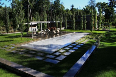 Elegant inground pool with automatic cover, outdoor seating, and lush landscaping in Long Island. Modern inground pool with automatic cover and surrounding outdoor furnishings.