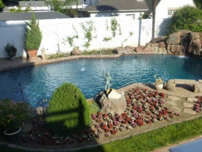 Custom inground pool with waterfall, landscaping, and outdoor furnishings in Long Island. Beautiful inground pool with waterfall and garden in Long Island.