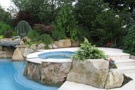 Elegant inground pool with natural rock accents and surrounding greenery in Long Island outdoor space. Beautiful inground pool with rock features and lush landscaping in Long Island.