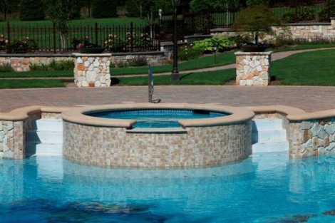 Custom inground pool with hot tub, stone accents, and outdoor living space in Long Island, NY. Luxury inground pool with hot tub and stone accents in Long Island.