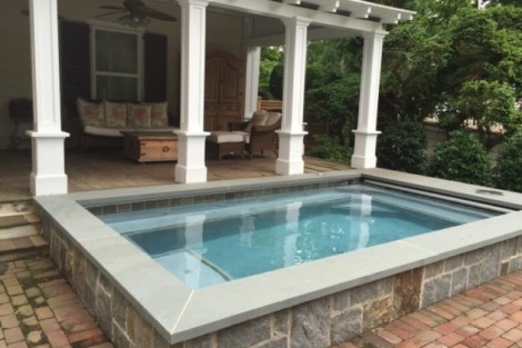 Elegant inground pool with stone border and outdoor lounge on Long Island. Beautiful inground pool with stone border and outdoor seating area.
