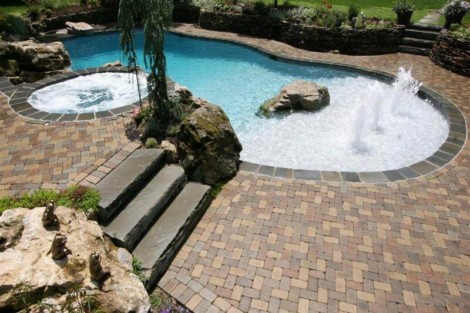 Elegant inground pool with water features, hot tub, and landscaped surroundings in Long Island, NY. Beautiful inground pool with water features and hot tub in Long Island.
