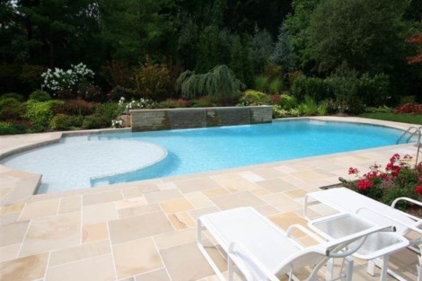 Beautiful inground pool with surrounding outdoor furniture and lush garden in Long Island, perfect for outdoor relaxation. Inground pool with lush landscaping and outdoor furnishings in Long Island.