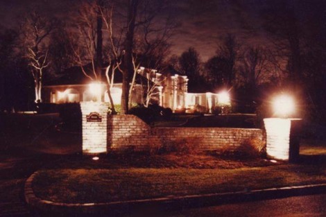 Beautiful outdoor lighting enhances the elegance of this estate at night, highlighting landscape features and architecture. Nighttime outdoor lighting illuminating a luxurious estate.