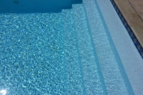 Beautiful inground pool with steps and crystal-clear water, perfect for outdoor relaxation in Long Island. Inground pool with steps and clear blue water in Long Island.