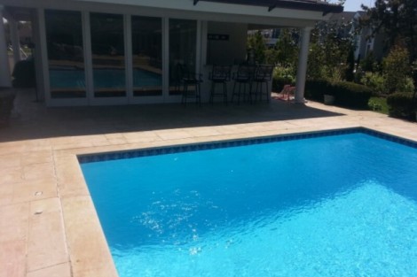 Modern inground pool with outdoor seating area in a residential backyard in Long Island. Beautiful inground pool with outdoor furnishings in Long Island.