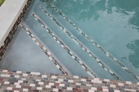 Luxury inground pool with mosaic tile steps and outdoor furnishings in Long Island, perfect for outdoor living. Inground pool with mosaic tile steps and outdoor furnishings in Long Island.