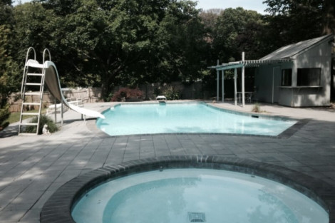 Beautiful inground pool and hot tub installed by All Island Group in Long Island with outdoor seating and lush greenery. Inground pool and hot tub with outdoor furnishings in Long Island.