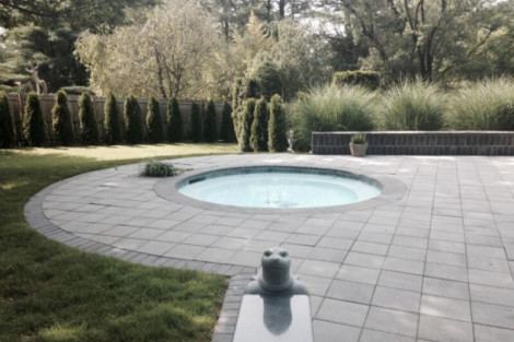 Beautiful inground pool with outdoor furnishings and lush greenery in Long Island, perfect for outdoor relaxation. Inground pool with surrounding patio and lush landscape in Long Island.