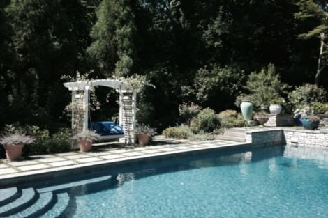 Elegant inground pool with outdoor seating area and lush landscaping in Long Island, perfect for outdoor living. Beautiful inground pool with outdoor seating and lush greenery in Long Island.