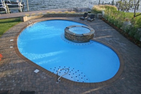 Custom inground pool with hot tub and outdoor seating, perfect for outdoor living in Long Island. Beautiful inground pool with hot tub and outdoor furnishings in Long Island.