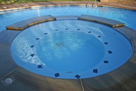 Beautiful inground pool with seating area and tile accents, perfect for outdoor relaxation and entertainment. Inground pool with built-in seating and blue tile accents on Long Island.