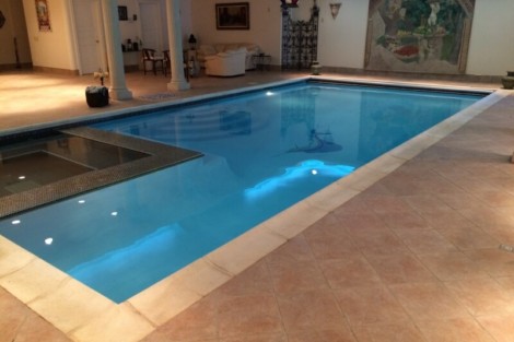 Luxurious indoor inground pool with elegant surroundings and outdoor furniture in Long Island. Indoor inground pool with modern design and outdoor furnishings.